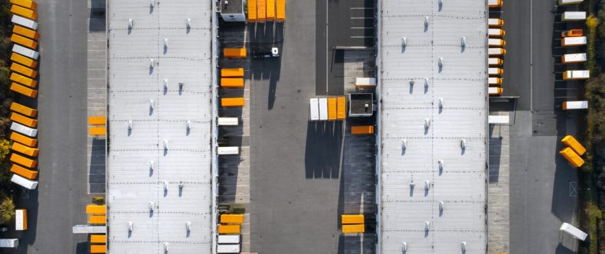Aerial view of a warehouse with trucks and loading docks.
