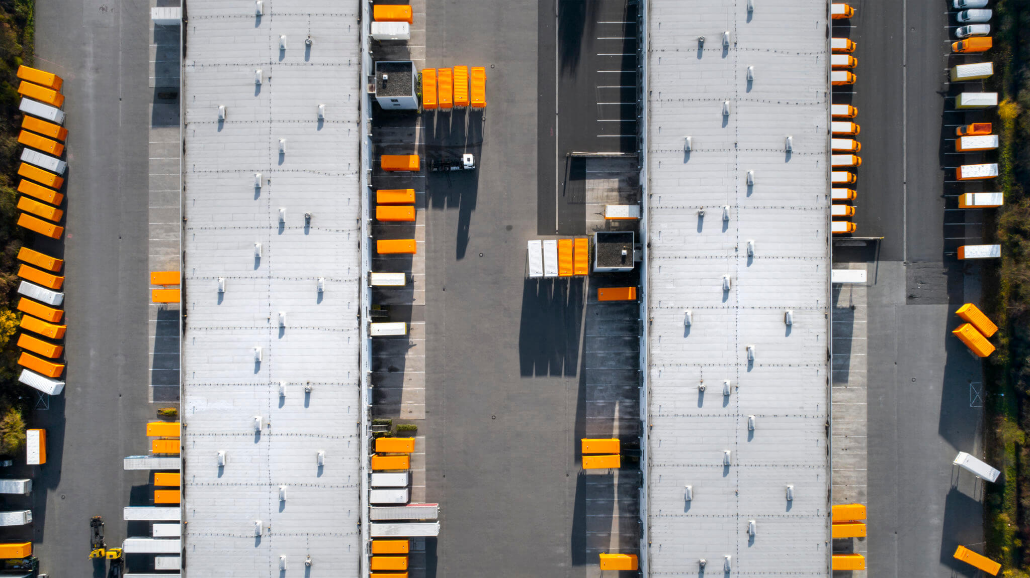 Aerial view of a warehouse with trucks and loading docks.