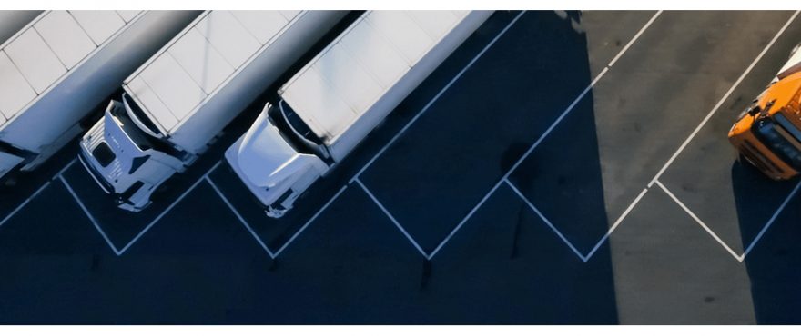 A white car is parked in a marked space at night.